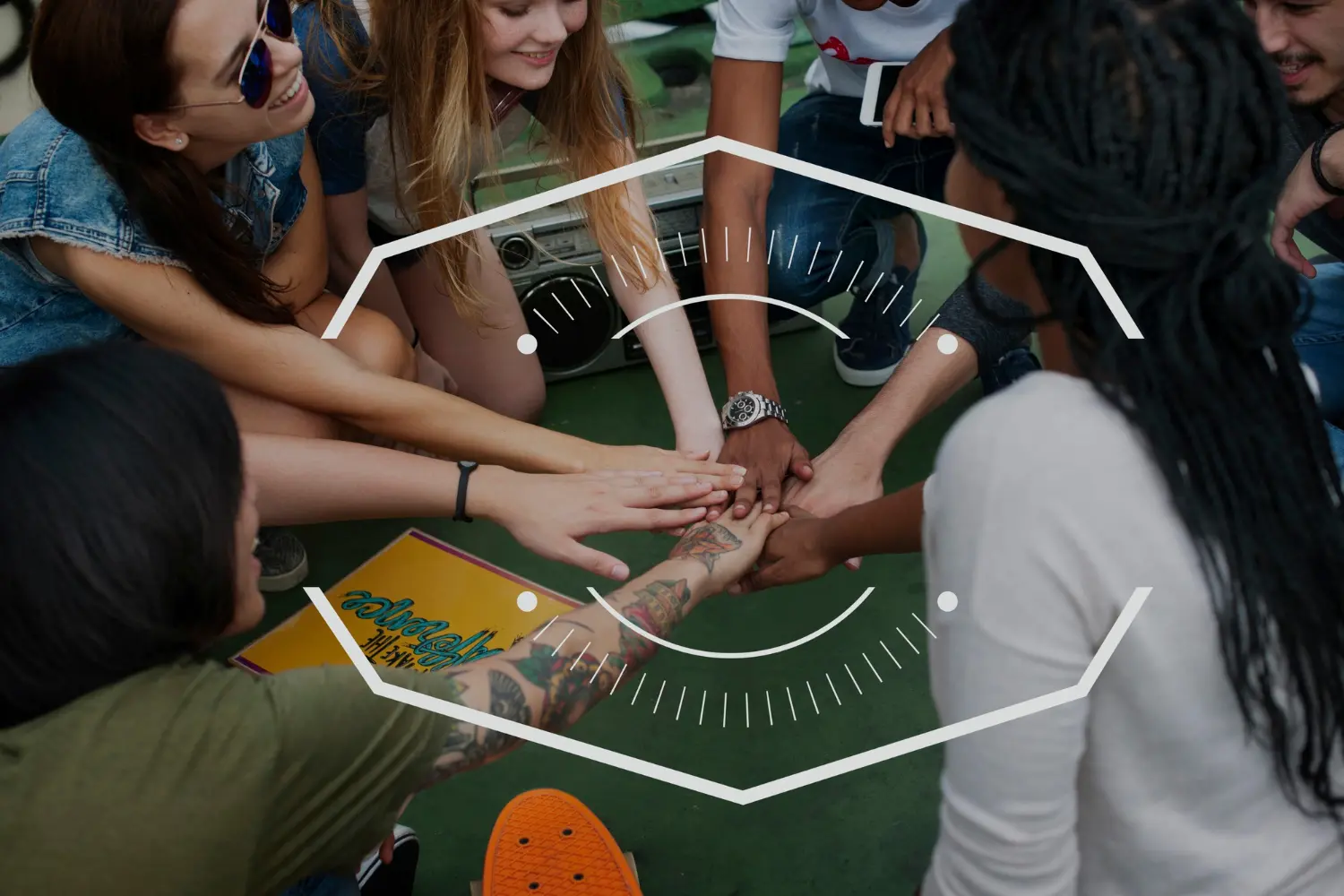 A diverse group of young creatives stacking their hands together in a circle, featuring a geometric badge overlay.